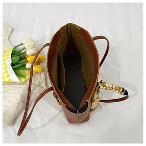 Top-down view of brown tote bag interior with green lining and floral silk scarf detail
