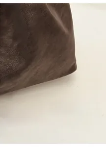 Detail shot of deep brown leather tote showing the natural pebbled texture and fine finish