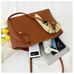 Top view of brown leather tote bag interior capacity with tablet and daily essentials