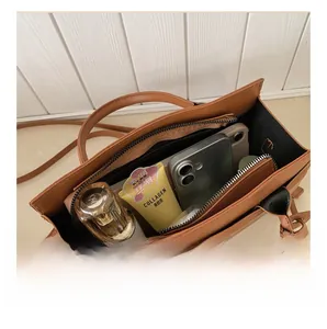 Vue détaillée du compartiment intérieur spacieux et de la poche zippée du sac fourre-tout brun