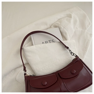 Vue à plat d'un sac à bandoulière bordeaux vintage avec poches à rabat et chaîne argentée
