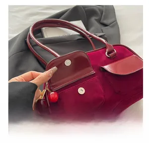 Detail of red leather shoulder bag with cherry charms and metal magnetic snap closure