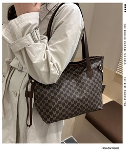 Detail of coffee brown tote bag with M-letter monogram print and leather straps