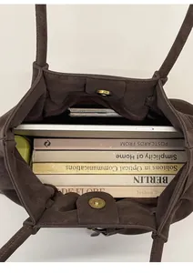 Top view of large dark brown tote bag showing spacious interior with books and a tablet