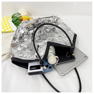 Detail showing high capacity of silver sequin tote bag with tablet and daily essentials