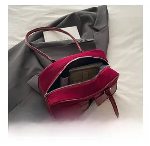 Interior view showing capacity of the burgundy suede Boston bag for daily essentials
