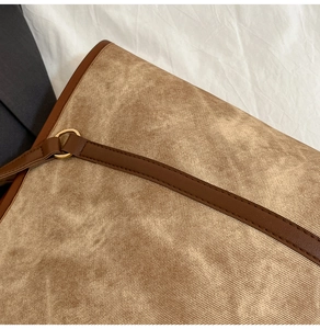 Close-up of textured fabric tote bag with premium leather trim and bronze metal rings