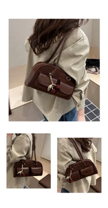 Close-up of retro brown shoulder bag with double pockets and cherry metal charm detail