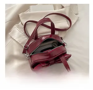 Interno della borsa in pelle bordeaux con fiocco che mostra la capienza dello scomparto