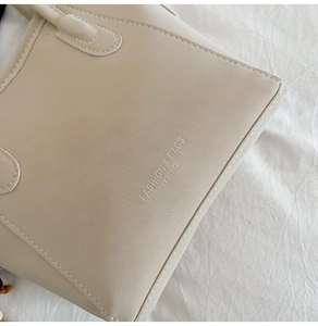 Detail of off-white PU leather bucket bag featuring fashion text print and neat stitching