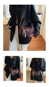 Macro detail of a dark brown hobo bag with suede texture and beaded wood charm