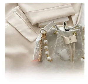 Détails du sac seau en dentelle blanche avec papillon 3D et poignée en perles