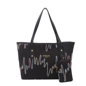 Minimalist black tote bag with colorful wave embroidery and a small matching pouch