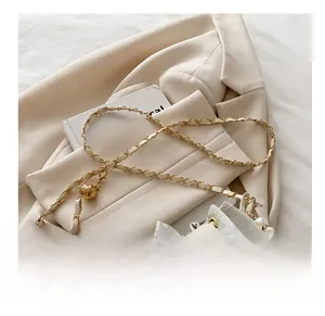 Détail du sac seau en dentelle blanche avec poignée en perles et bandoulière chaîne