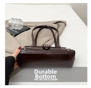 Gros plan sur la base résistante à l'usure et les rivets de ce sac vintage en cuir huilé