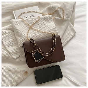 Detail of dark brown chain crossbody bag showing capacity compared to a smartphone