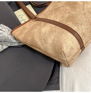 Close-up of contrast large tote bag featuring vintage texture and premium leather straps