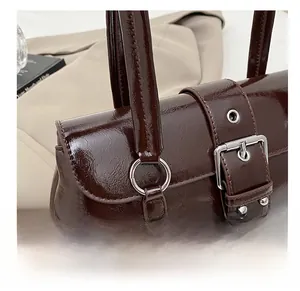 Gros plan détaillé de la texture en cuir verni marron foncé avec rivets argentés