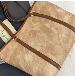 Detailed macro shot of vintage beige tote bag material with brown leather strap and gold ring