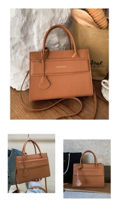 Detail view of brown crocodile embossed faux leather bag with elegant gold foil lettering