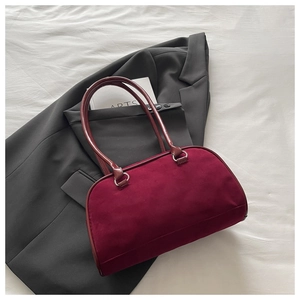 Detail of burgundy vintage handbag with matte suede texture on minimalist suit background