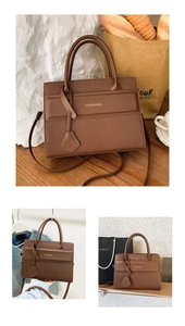 Close-up of brown crocodile embossed handbag with gold logo and dual handles