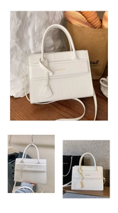 Detailed macro view of white crocodile pattern texture and gold brand logo on tote bag