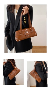 Gros plan du sac baguette en cuir ciré marron vintage avec détails de rivets argentés