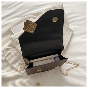 Detail view of the deep brown crossbody bag interior with gold magnetic buckle closure