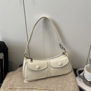 Chic cream white baguette bag with double front buckle pockets on a cozy knit surface