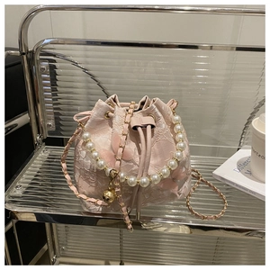 Détail du sac seau en dentelle rose avec papillons 3D et chaîne à main en perles