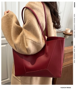 Detail of burgundy leather tote bag with geometric stitching on female model
