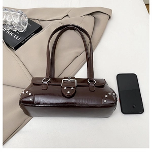 Nahaufnahme der braunen Vintage Baguette-Tasche aus Ölwachsleder mit Nieten und Schnallen