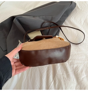 Detail of retro crescent crossbody bag featuring vintage brown suede and wooden bead strap