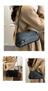 Detail of black shoulder bag with vintage leather straps and silver buckles