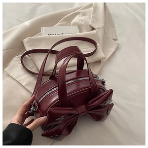 Macro shot of dark red leather handbag with 3D bow and star rivets detailing