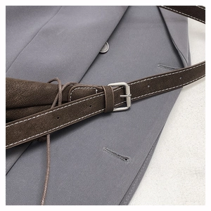 Detail of dark brown pebble leather strap with silver pin buckle and contrast stitching