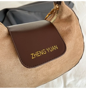 Detail shot of the khaki suede and brown leather contrast on the stylish shoulder bag