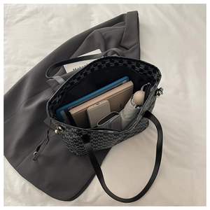 Internal storage detail of black tote bag showing capacity for tablet and accessories