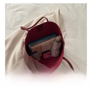 Spacious interior of burgundy tote bag showing capacity for tablet, umbrella and wallet