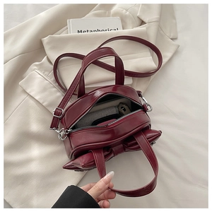 Top view of deep red bow handbag interior showing space for phone and small items