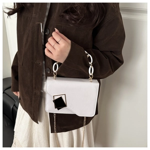 White PU leather crossbody bag with resin chain strap shown on model's outfit