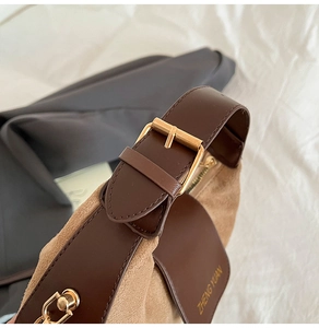 Macro shot of retro crossbody bag metal buckle and suede texture with gold logo