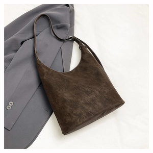 Detail of dark brown matte leather hobo bag with contrast stitching on grey blazer
