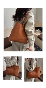 Detail view of large brown tote bag showing geometric stitching and protective base studs