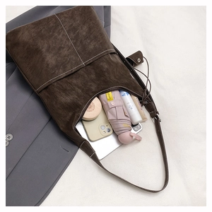 Detail of a large capacity coffee suede tote bag showing internal storage for daily items