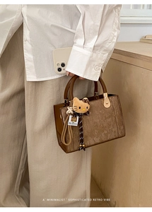 Minimalist retro handbag with brown corduroy texture and plush leopard kitty charm