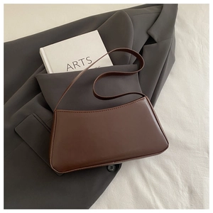 Detail of minimalist dark brown leather underarm bag with refined stitching and shoulder strap