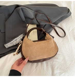 Detail of retro half-moon crossbody bag in khaki suede and brown leather with wood beads