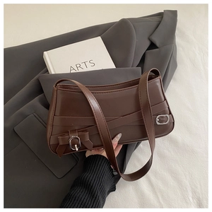 Detail view of brown vintage shoulder bag with cross straps and silver buckle finish